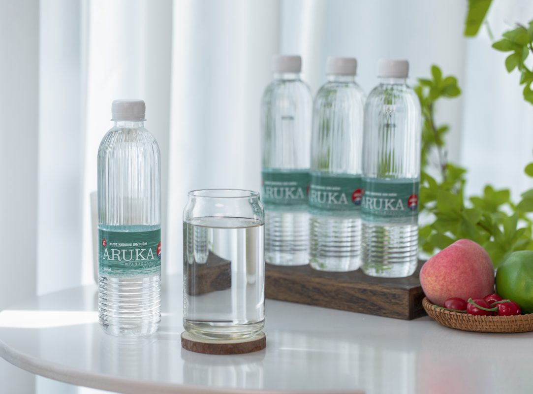 Chai nước khoáng kiềm tự nhiên ARUKA và ly nước